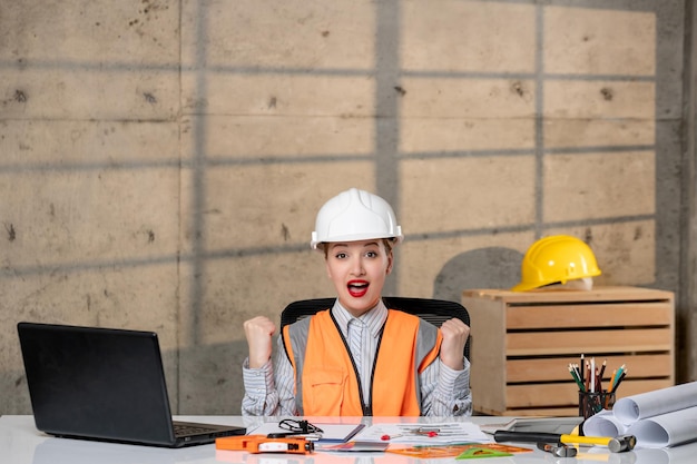 Ingeniero inteligente joven linda chica rubia trabajadora civil en casco y chaleco muy orgulloso