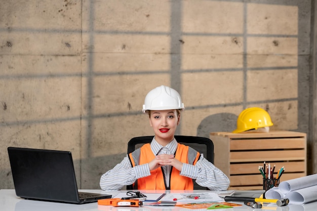 Ingeniero joven inteligente linda chica rubia trabajadora civil en casco y chaleco que tiene una idea