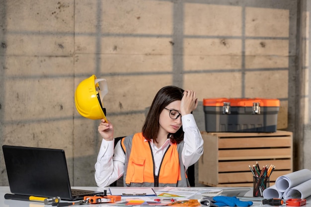 Foto gratuita ingeniero joven linda chica morena inteligente trabajador civil en casco y chaleco muy cansado