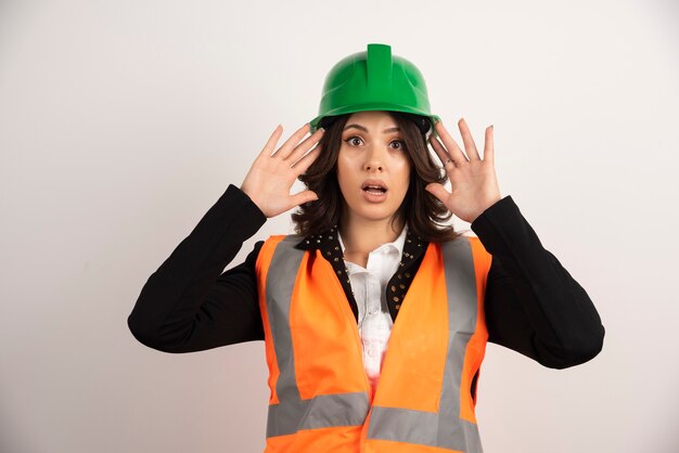 Ingeniero mujer actuando sorprendido en blanco