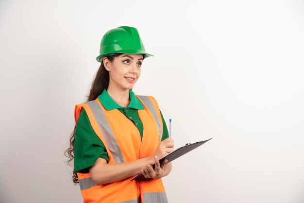 Foto gratuita ingeniero de mujer sonriente con portapapeles sobre fondo blanco. foto de alta calidad