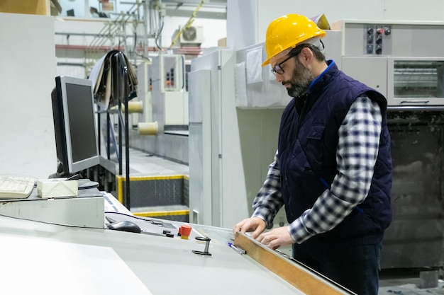 Ingeniero serio en vidrios que opera la máquina