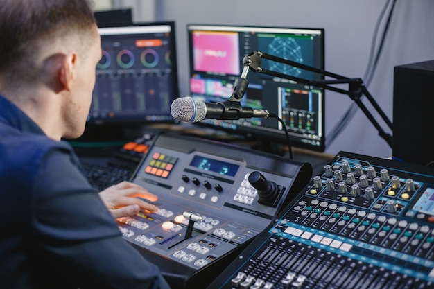 Ingeniero de sonido trabajando en estudio con equipo.