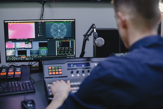 Ingeniero de sonido trabajando en estudio con equipo.