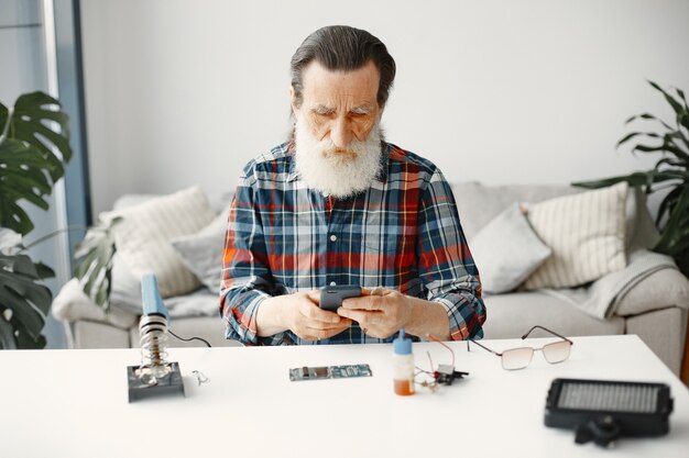 Ingeniero superior comprobar teléfono después de la reparación. Rehabilitación de gadgets.