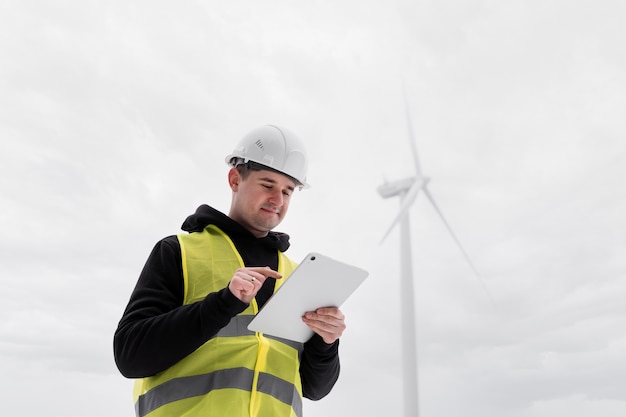 Ingeniero de tiro medio sosteniendo tableta afuera