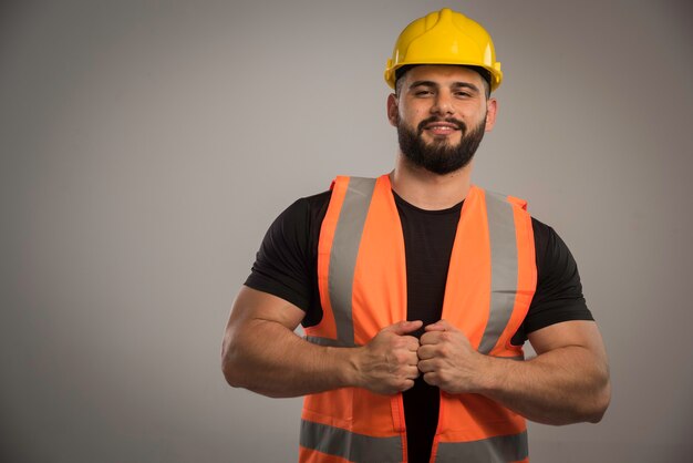 Ingeniero en uniforme naranja y casco amarillo parece seguro