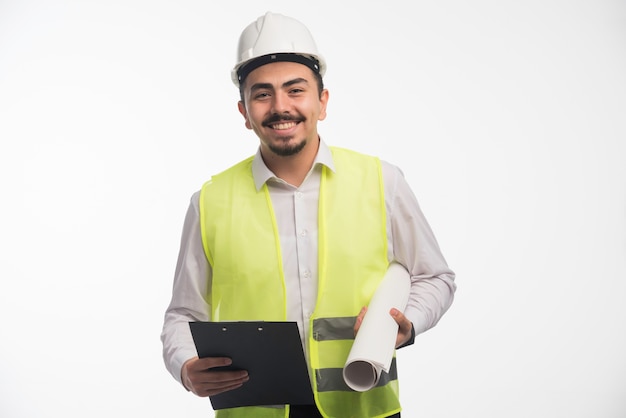 Ingeniero en uniforme con plan de proyecto y lista de tareas.