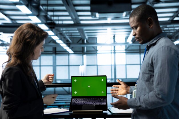Ingenieros en el centro de datos que utilizan una computadora portátil de maqueta de pantalla aislada