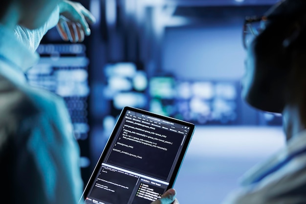 Los ingenieros codifican en la tableta en el centro de datos