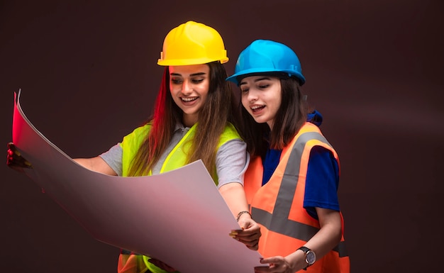 Ingenieros de la construcción mujeres trabajando juntos y discutiendo el plan del proyecto.