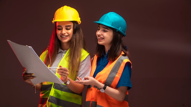 Foto gratuita ingenieros de la construcción mujeres trabajando juntos y discutiendo el plan del proyecto.