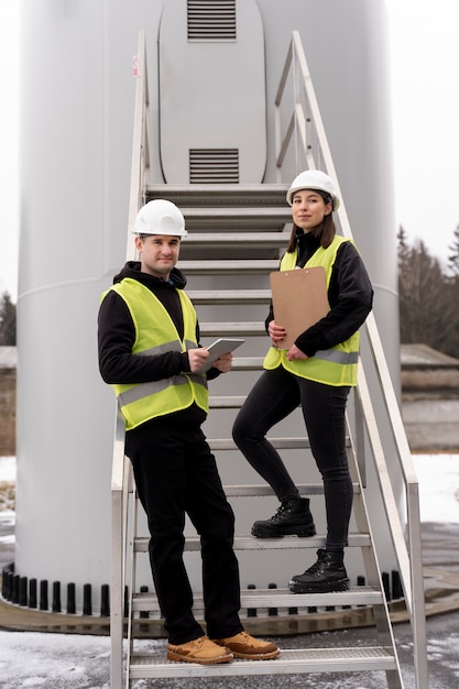 Foto gratuita ingenieros sonrientes de tiro completo al aire libre