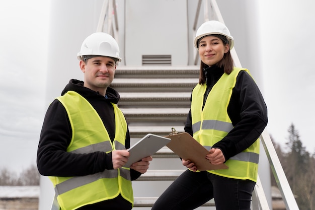 Foto gratuita ingenieros sonrientes de tiro medio al aire libre