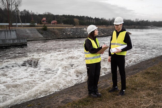 Ingenieros de tiro completo parados cerca del río.