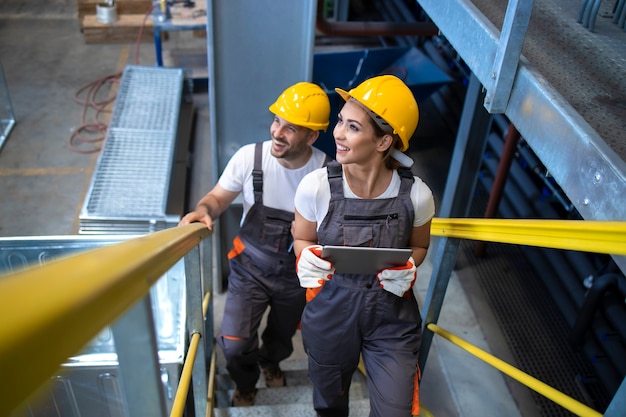 Foto gratuita ingenieros de trabajadores industriales caminando en la fábrica y subiendo escaleras metálicas