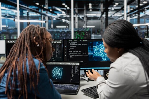 Ingenieros trabajando juntos inspeccionando el centro de datos de la red neuronal