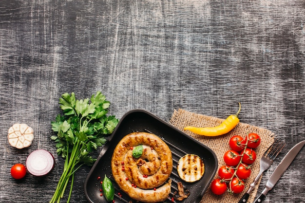 Foto gratuita ingrediente fresco y sabroso y salchichas fritas de caracol en el fondo de la textura de madera gris