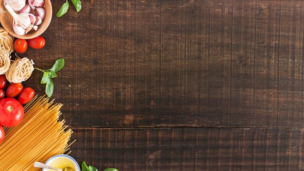 Ingredientes para cocinar pasta sobre fondo de madera.