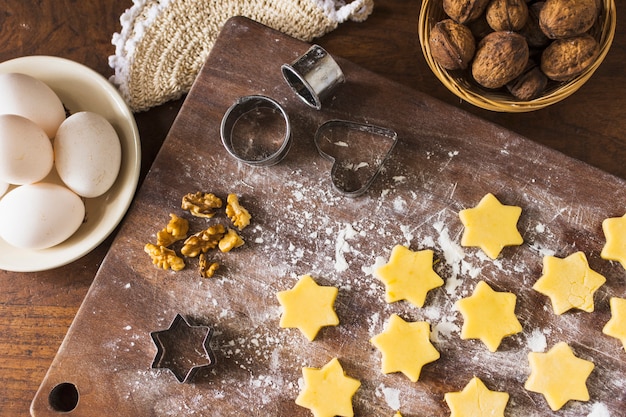 Ingredientes y cortadores de galletas cerca de galletas crudas