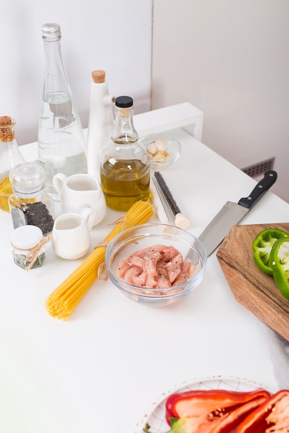 Ingredientes para hacer los espaguetis en mesa blanca.