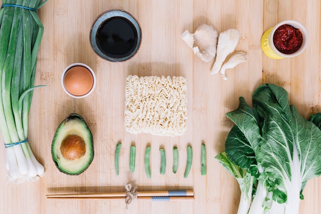 Ingredientes para hacer fideos en mesa de madera.