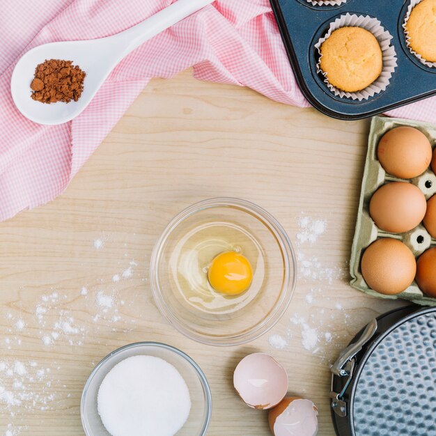 Ingredientes y herramientas para hacer un pastel en el escritorio de madera.