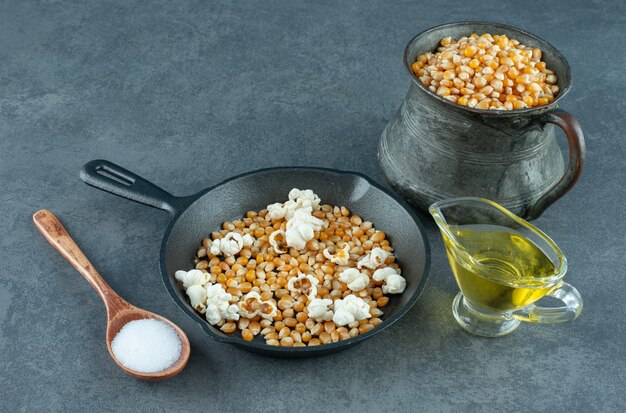 Ingredientes para preparar palomitas de maíz caseras sobre fondo de mármol. Foto de alta calidad
