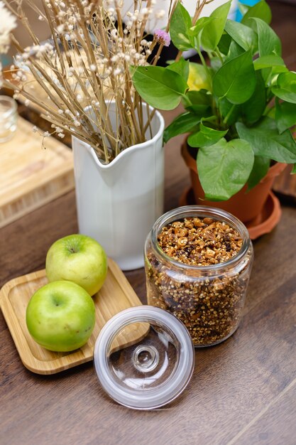 Ingridients para desayuno saludable, pudín de chía en mesa de madera. Almendras, manzanas, anacardos, dátiles, cacao, granola.