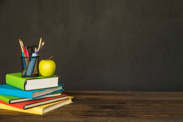 Inmóvil y manzana en la pila de libros en la mesa