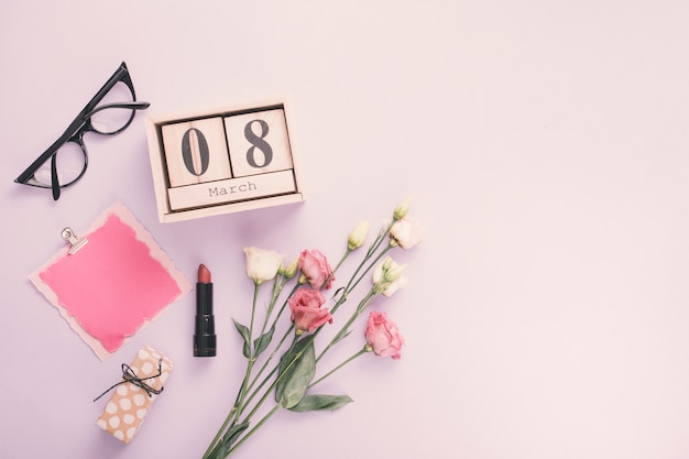 Foto gratuita inscripción del 8 de marzo con papel y flores rosas en mesa.