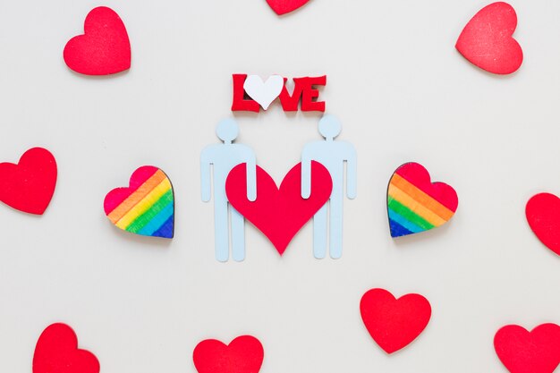 Inscripción de amor con corazones de arco iris y un ícono de pareja gay