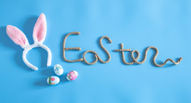 Foto gratuita inscripción creativa de pascua en azul con elementos de decoración de pascua.