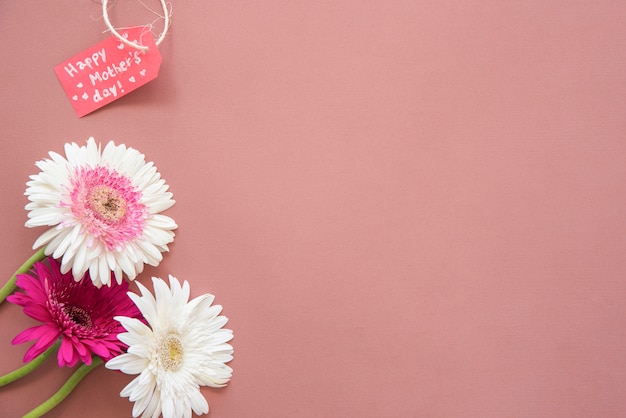 Inscripción del día de la madre feliz con flores de gerbera