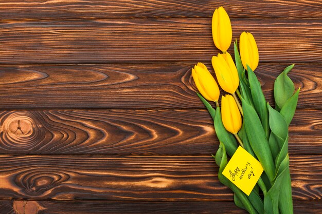 Inscripción del día de la madre feliz con flores de tulipán