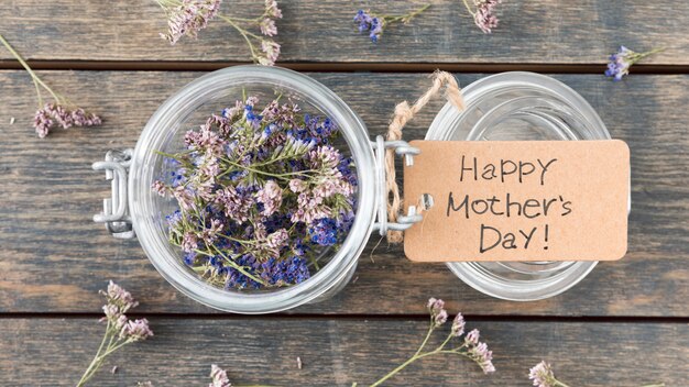 Inscripción del día de la madre feliz con pequeñas flores en lata