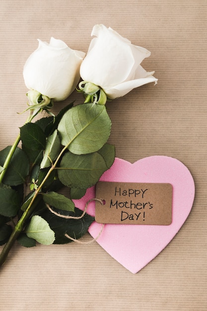 Inscripción del día de la madre feliz con rosas y corazón de papel
