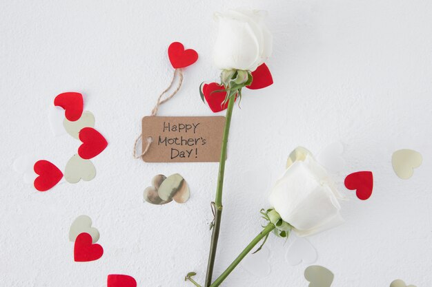 Inscripción del día de la madre feliz con rosas y corazones