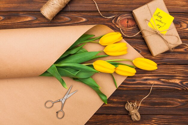 Inscripción del día de la madre feliz con tulipanes y regalo