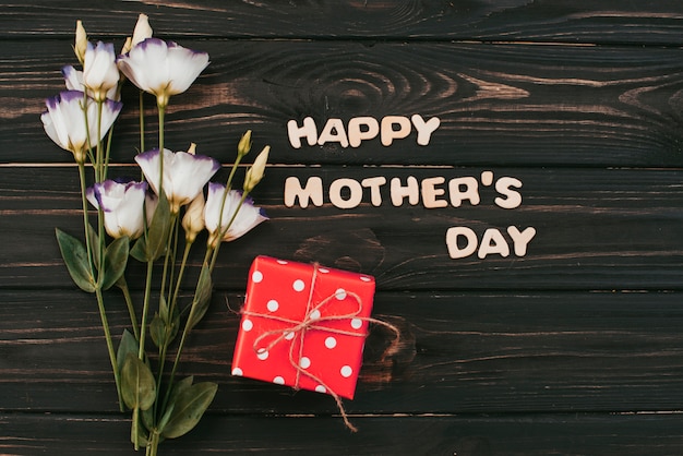 Inscripción del día de las madres felices con flores y regalos