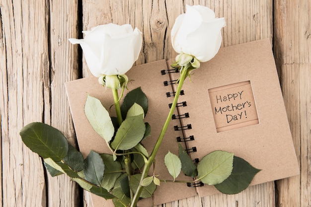 Inscripción feliz día de la madre en cuaderno con rosas
