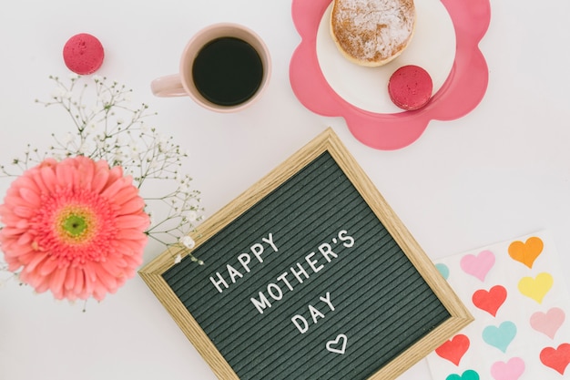 Inscripción de feliz dia de las madres con cafe y flor