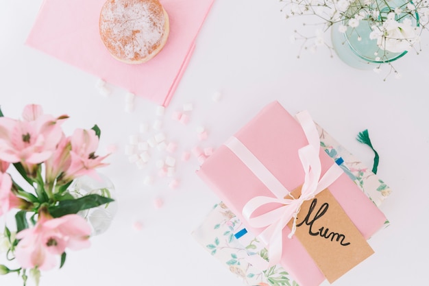 Inscripción de mamá con caja de regalo, flores y donut.