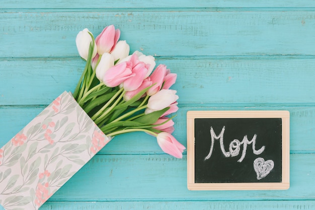 Inscripción de mamá en pizarra con ramo de tulipanes
