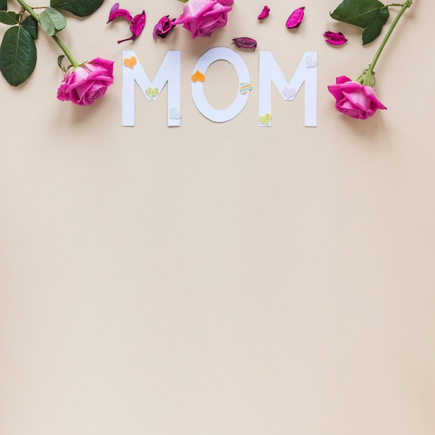 Inscripción de mamá con rosas en mesa