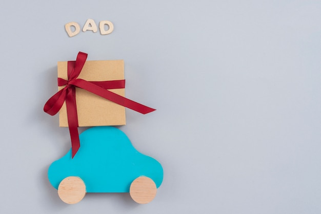 Inscripción de papá con caja de regalo y carro pequeño.