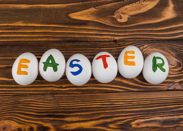 Inscripción de Pascua en huevos blancos en mesa