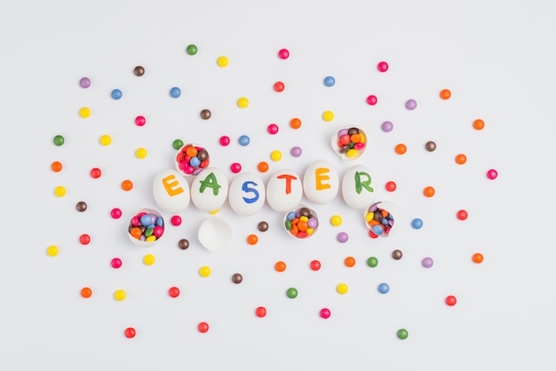 Inscripción de Pascua en huevos con dulces en mesa de luz