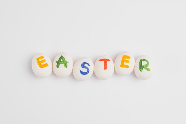 Inscripción de Pascua en huevos en mesa blanca