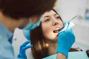 Foto gratuita inspección de los dientes de la mujer con la ayuda de un espejo.